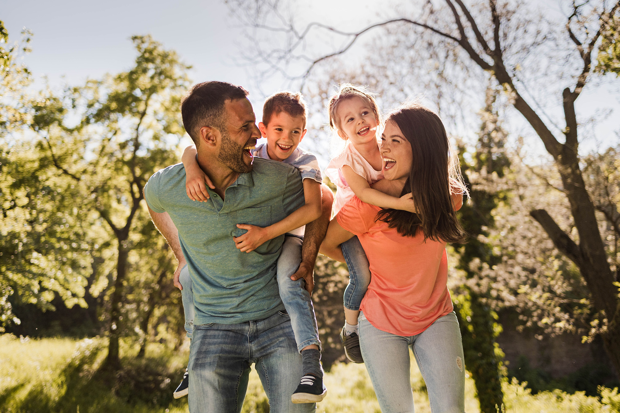 Parents giving piggyback rides to kids in San Diego nature